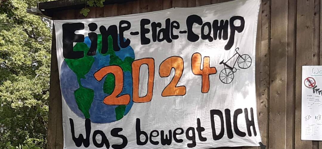 Eine-Erde-Camp 2024 Banner mit Weltkarte und Fahrrad - Was bewegt dich.