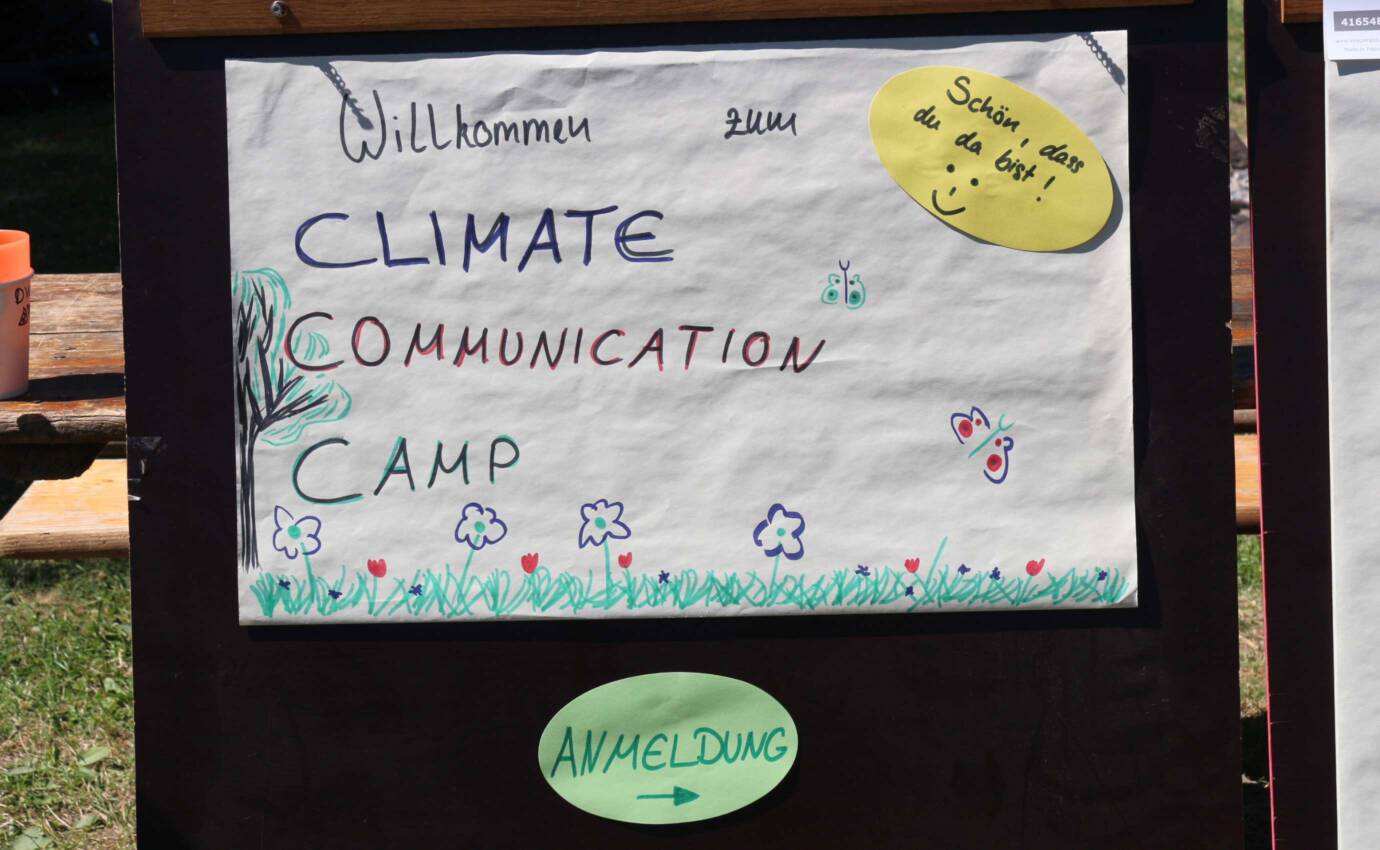 Plakat vom Climat Communication Camp zum Willkommen sagen
