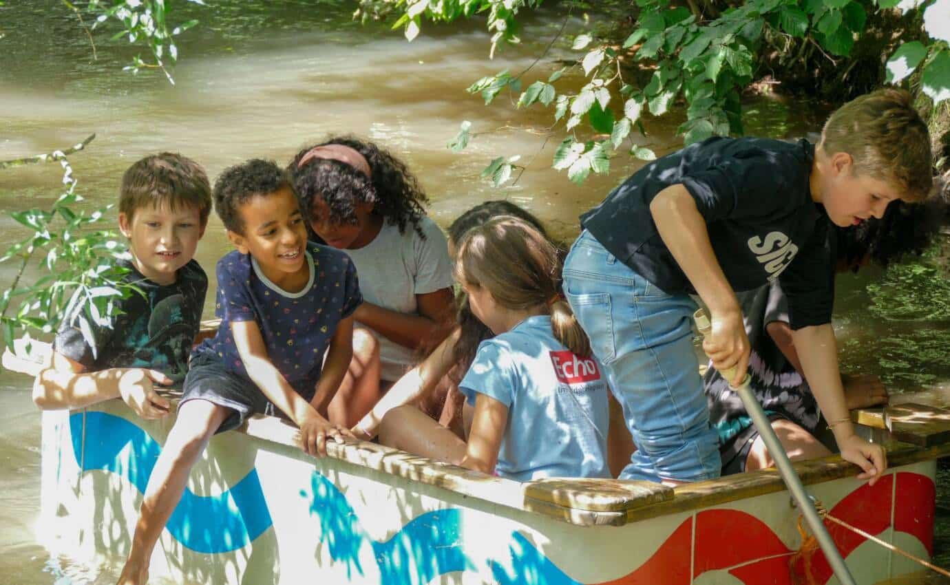Kinder spielen auf einem Boot im Wasser.
