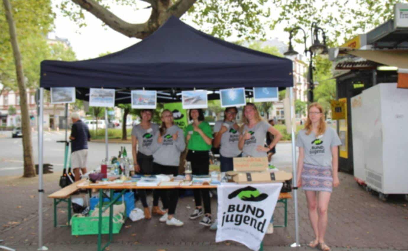Gruppe unter Pavillon bei Infostand im Freien