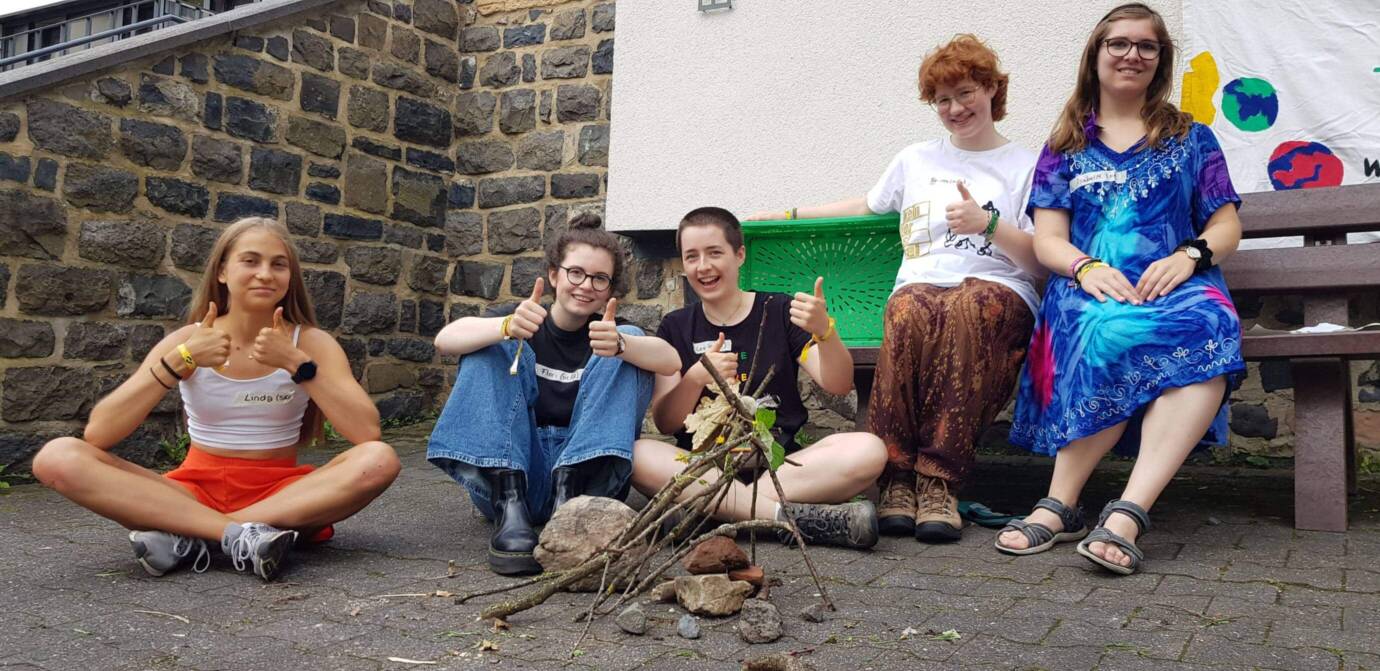 Fünf Personen draußen mit Daumen hoch.