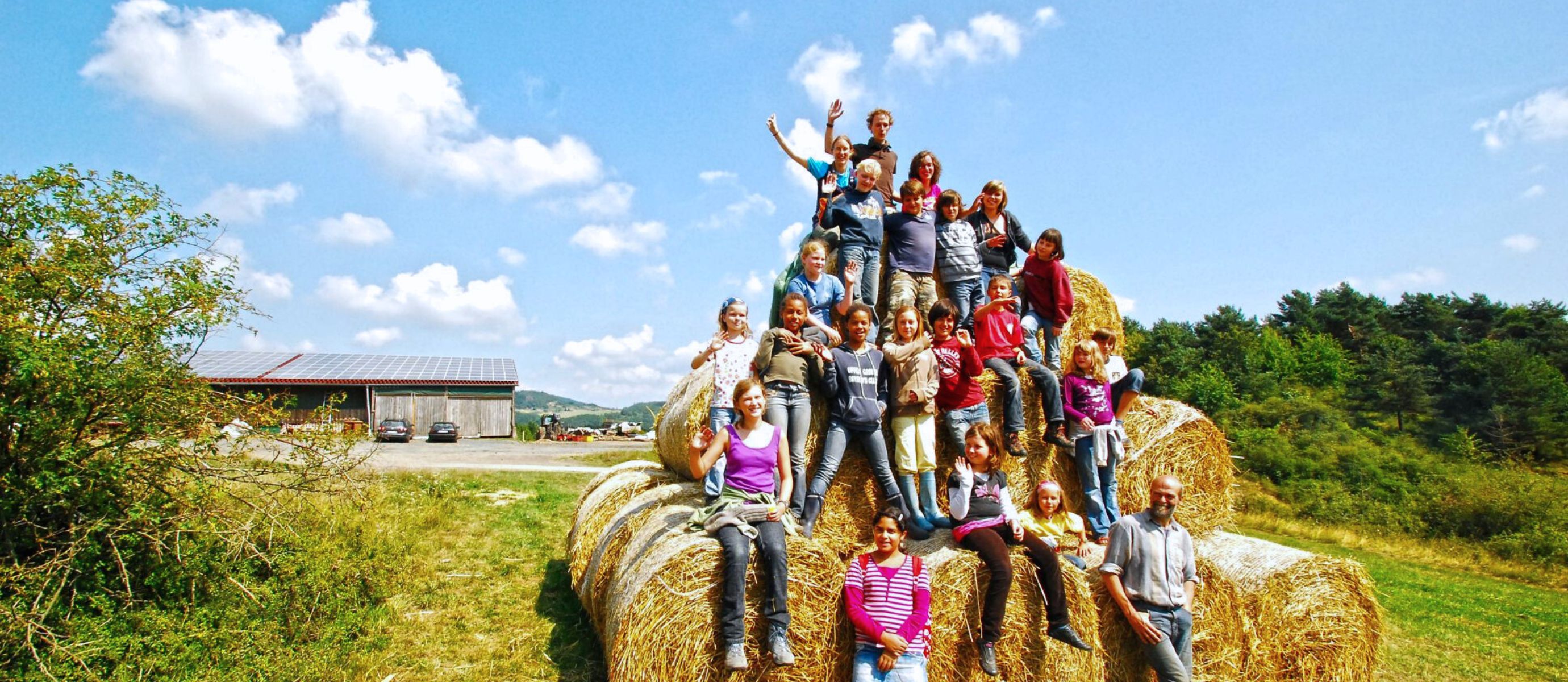 Gruppe von Kindern auf Heuballen im Freien