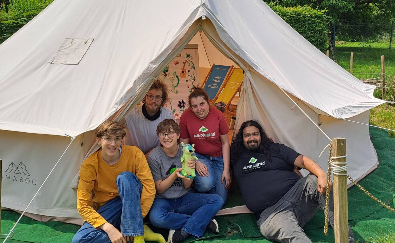 Fünf Personen vor einem weißen Zelt