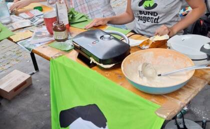 Tisch mit Waffeleisen und Backzubehör bei einem Event.