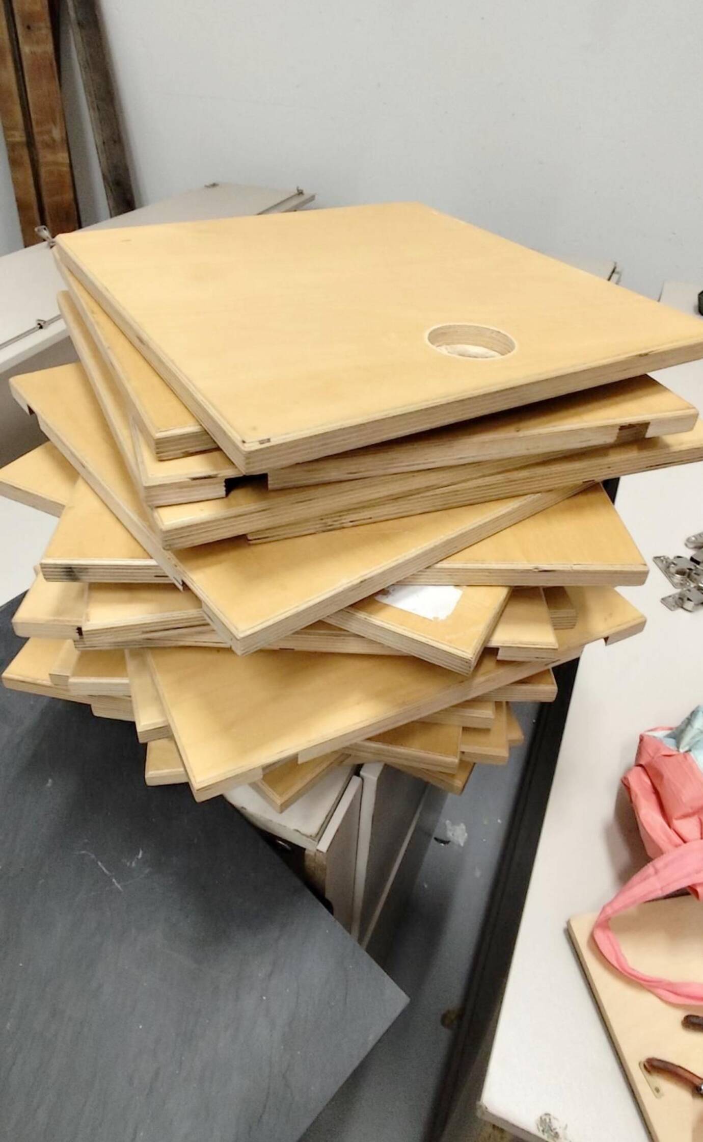 Gestapelte, quadratische Holzplatten.