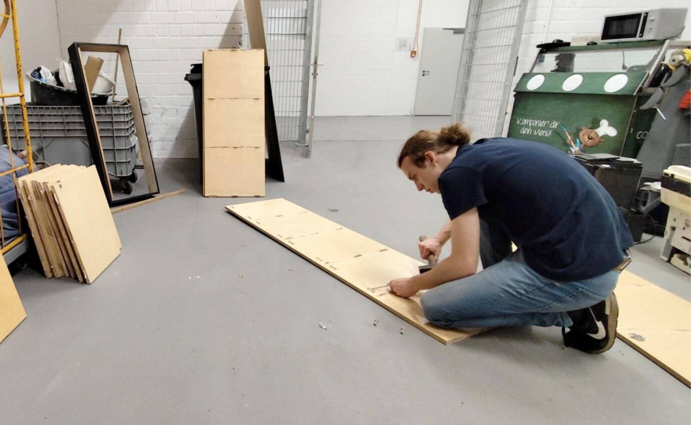 Eine Person arbeitet an einer Holzplatte.